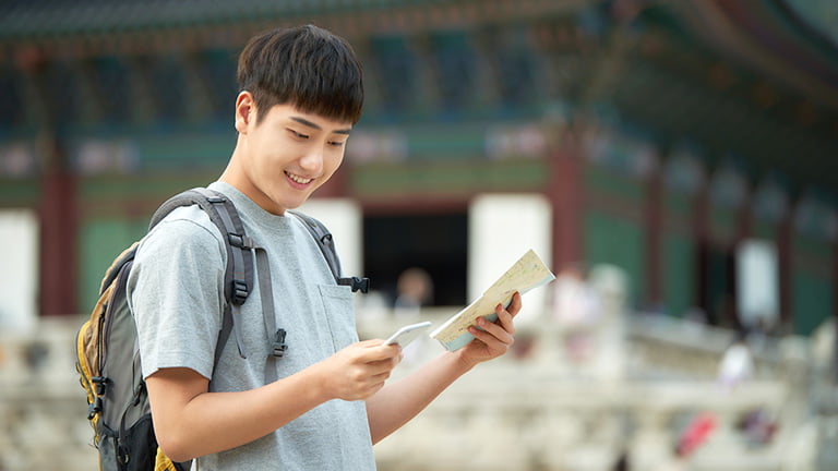 A-solo-man-traveler-utilitzing-eSIM-Korea-with-his-phone-while-traveling-Korea